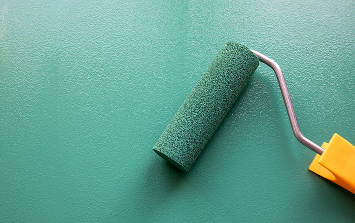 green paint roller and wall